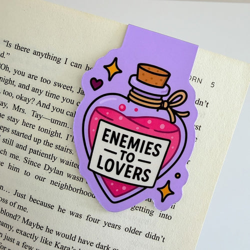 Enemies to Lovers magnetic bookmark clipped to an open book page
